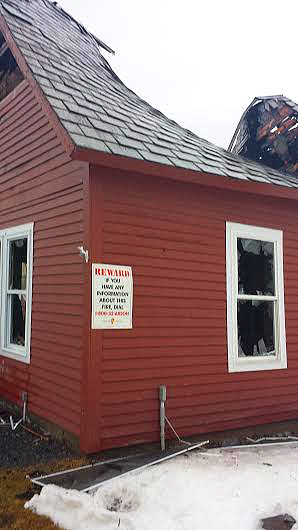 A sign on the outside of the Yankee Ingenuity Antiques shop announces a reward for information into the fire. Police photo.