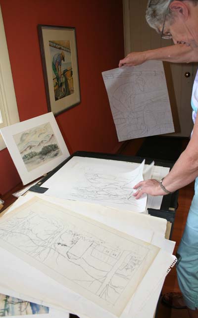 Ann Summers of the Chester Bookworm looks over the sketches that will accompany some of the paintings for sale. The one in her right hand is a study by George Winston for one of two paintings on the wall above. Click photo to enlarge.
