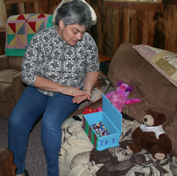 Mom Sue Willis gently handles the glass beads in Lindsey's collection.
