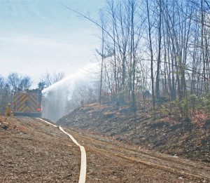 A pumper shoots water on the ground blaze.
