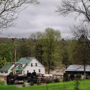 The 18-wheel tanker truck lies on its side on Route 11. The Williams River is in the background. Photo by Casey Savage. Click photo to launch gallery.