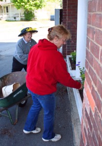 Jane Davis, donning a hat worthy of the Preakness, and Nancy Rugg prepare another Town Hall window box.
