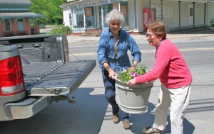 Cheryl LeClair and Tory Spater offload a planter for placement at the pavilion across from Town Hall.