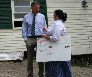 Fenton Road resident Jan Rounds holds the sign she made inviting Gov. Shumlin, right, to visit her damaged yard.