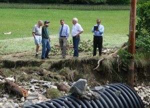 Graham Kennedy of the Chester Highway Department points to the road and washed out culvert off Potash Brook Road. Gov. Shumlin stands in the middle, with town manager David Pisha and Brian Searles of the state Highway Department. All photos by Shawn Cunningham