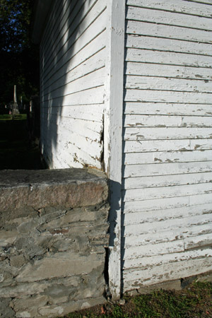 Clapboards are buckling next to one wall. 