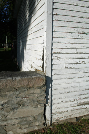 Clapboards are buckling next to one wall.