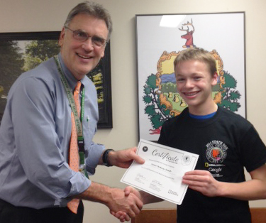 Green Mountain Principal Tom Ferenc, left, presents Chase Ordway-Smith with a certificate recognizing his recent Geo Bee win.