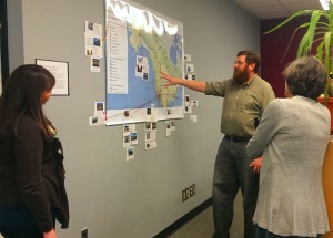 Keighan Chapman, left, teacher Jason Rickles and Secretary Holcombe look at the mapping project.