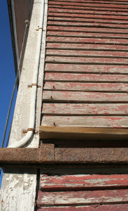 Nails protrude from siding above the sliding door.