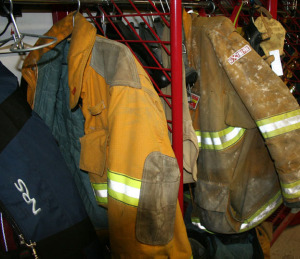 Firefighters' turnout gear hangs in the locker-lounge space, some waiting to be cleaned. Each set of gear costs about $2,500.