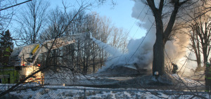 Steam rises from the flames of the Moniers' Elm Street home. All photos by Shawn Cunningham unless otherwise noted.