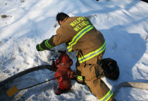 A Walpole firefighter opens up a hydrant on Grafton Street during the March 6 fire.