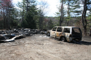Beyond the wreckage of the garage and car, a brush fire spread down the hill toward the road. 