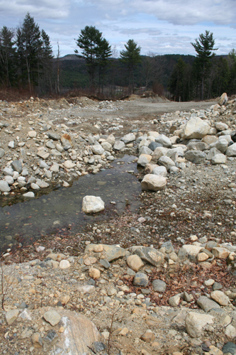 A field of pre-gravel boulders on the site.