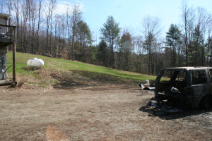 The burnt grass, center, shows how close flames came to the 500 gallon propane tank just feet from the house at left. 