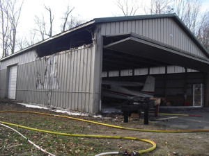 The fire spread up the hill stopping short of an airplane hangar on East Hill Road. The windows at the top of the wall melted and the interior was scorched. 