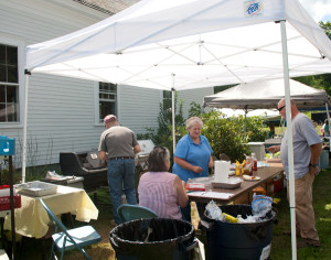 Town Clerk Linda Bargfrede, in blue, serve customers seeking sustenance while her husband David mans the grill and her sister Diane Parker.