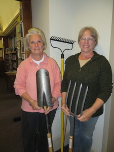Lillian Willis, left, presents garden tools to Whiting director Sharon Tanzer.