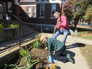 Suzy Forlie, at left, and Mariette Bock plant bulbs in front of the Whiting Library.