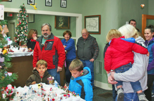 Ken and Shirley Barrett, center rear, look on as visitors explore the holiday display