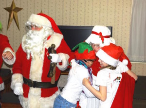 Santa and Mrs. Claus receive a thank you hug from the Kurn Hattin girls.