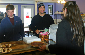 Mike Fogerty buys a pie from Vicki Thornton as Fogerty's son Aidan checks out plates of pie samples