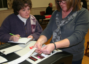 Julie Hance, left, executive assistant to the town manager, and Town Clerk Deb Aldrich print out the results from the optical ballot reader.