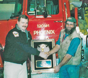 Ameden presents former Fire Chief Jesse Pomeroy with a plaque. Photo provided.
