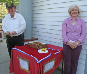 Galen Pinkham, left, stands next to Mary Feder's cookie and good-will filled table as Feder offers her homemade cookies to meeting attendees. Photos by Cynthia Prairie. Click photo to enlarge.