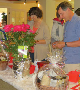 Melody Reed, left, and Jeff Ladd look over raffle items at the 6th annual Chester Rotary-GMUHS Alumni Association Golf Tournament.