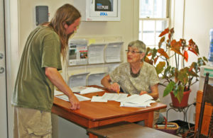 A voter picks up a ballot from Joan Lake on Tuesday. Photos by Shawn Cunningham.