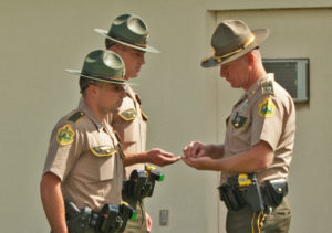 Troopers Anthony Frissora, left, and Sean Rielly receive one year pins from Barracks Commander Lt. Timothy Oliver