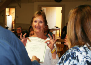 Erron Carey displays her award for 34 years of service to the town.