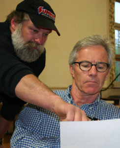 Michael Normyle, right, in this 2014 Telegraph photo, looks at documents with a town resident.