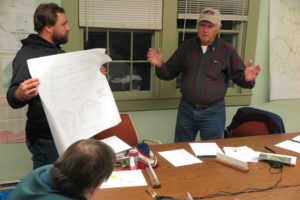 Board member Bill Wylie describes the concept of the wood construction salt shed as Will Reed holds up a plan Photo by Bruce Frauman