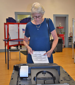 Esther Fishman slides her ballot into Londonderry's optical scanner